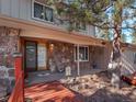Charming home with a stone facade, a covered entryway, and a wood-plank deck at 28735 Little Big Horn Dr, Evergreen, CO 80439