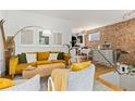 Bright living room with mustard yellow couch and two accent chairs at 1217 E 26Th Ave, Denver, CO 80205