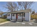 Exterior shot of the home showing a red front door, dark shutters and gray gravel front yard at 1120 Quince St, Denver, CO 80220