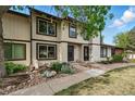 Charming townhouse with neutral siding, a dark front door, and a beautiful rock and garden landscape at 3571 S Kittredge St # C, Aurora, CO 80013