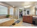 Bright bathroom with a soaking tub, walk-in shower, and vanity with ample counter space at 2015 E 167Th Ln, Thornton, CO 80602