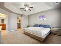 Spacious bedroom featuring a tray ceiling, ceiling fan, and neutral color palette at 2015 E 167Th Ln, Thornton, CO 80602