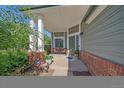 Inviting front porch with brick accents and cozy seating area at 10421 Kennemere Ln, Parker, CO 80134