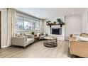Bright living room with a fireplace, featuring hardwood floors and modern decor at 6661 Lamar St, Arvada, CO 80003
