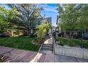 Inviting home featuring a well-maintained lawn, mature trees, and a charming walkway leading to the front door at 1057 N Emerson St # B, Denver, CO 80218