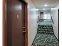 Hallway of a building featuring stairs with flower-patterned carpet, neutral walls, and updated lighting fixtures at 9650 Huron St # 3, Thornton, CO 80260