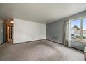 A sunlit living room with a large window offering neighborhood views and neutral paint, ready for personalization at 7917 Chase Cir # 160, Arvada, CO 80003