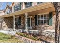 Inviting front porch featuring brick accents, decorative columns, and beautiful landscaping at 22261 Pebble Brook Ln, Parker, CO 80138
