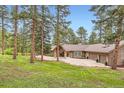 Charming house with stone accents, three-car garage, and a serene tree-lined front yard at 4856 Cheyenne Dr, Larkspur, CO 80118