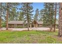 Charming house with stone accents, three-car garage, and a serene tree-lined front yard at 4856 Cheyenne Dr, Larkspur, CO 80118