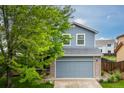 Charming two-story home with a well-maintained lawn and a blue exterior with brick accents at 2763 Dharma Ave, Broomfield, CO 80020