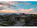 Stunning dusk shot of a home featuring stone accents and a two-car garage at 16392 Spanish Peak Way, Broomfield, CO 80023