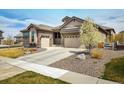 Inviting single Gathering home with a two-car garage, and rock landscaping with a fresh tree in bloom at 16392 Spanish Peak Way, Broomfield, CO 80023