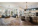 Open-concept living space with hardwood floors, dining area, and an airy living room at 16392 Spanish Peak Way, Broomfield, CO 80023