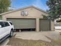 Spacious two-car garage featuring one open bay, a basketball hoop, and side yard access at 300 S Simms St, Lakewood, CO 80228