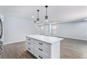Open kitchen layout with an island featuring a white countertop and a modern pendant light fixture at 1963 Hogan Ct, Castle Rock, CO 80109