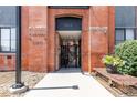 Main entrance to Fire Clay Lofts with brick surround and landscaped planter nearby at 3225 Blake St # 6, Denver, CO 80205