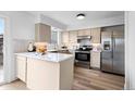Updated kitchen featuring stainless steel appliances, quartz countertops, and ample cabinet space at 5667 S Lowell Blvd, Littleton, CO 80123