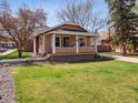Charming home with a well-manicured lawn featuring a cozy front porch and inviting curb appeal at 6940 W 48Th Ave, Wheat Ridge, CO 80033
