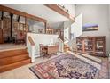 Bright open-concept living room features wood beams, brick fireplace and large area rug at 29089 Western Ln, Evergreen, CO 80439