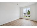 Bright, minimalist bedroom with a large window and modern, light-colored wood flooring at 24717 E 40Th Ave, Aurora, CO 80019