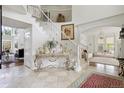 Bright foyer showcases a grand staircase with decorative ironwork and elegant tile flooring at 9479 S Shadow Hill Cir, Lone Tree, CO 80124