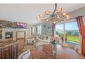 Open living space with fireplace, hardwood flooring, a view to the backyard, and stylish lighting at 6638 S Tibet Ct, Aurora, CO 80016