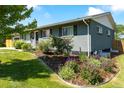 Lovely exterior view of a charming home with beautiful landscaping, plants, and grass at 3461 S Ivy Way, Denver, CO 80222