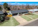 Inviting home features a spacious driveway, lush green lawn, attached garage, and meticulously maintained front yard landscaping at 3461 S Ivy Way, Denver, CO 80222