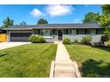 Inviting single-story home featuring a lush green lawn, sidewalk, and attractive landscaping at 3461 S Ivy Way, Denver, CO 80222