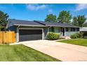Home showcasing a two-car garage with a paved driveway and well-maintained lawn at 3461 S Ivy Way, Denver, CO 80222