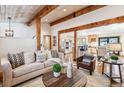 The bright living area flows into a spacious kitchen and dining area with wood-beam accents at 9019 Armadillo Trl, Evergreen, CO 80439