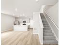 Bright living room and kitchen boast open floor plan, recessed lighting, and staircase at 765 N Tibet St, Aurora, CO 80018
