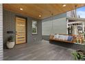 Spacious front porch featuring a wooden swing, tiled flooring, and a stylish front door at 2533 N Emerson St, Denver, CO 80205