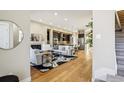 Open-concept living room with hardwood floors, fireplace, and flows into the modern kitchen at 5438 Valentia St, Denver, CO 80238