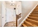 Welcoming entryway featuring tile flooring, a staircase with wood treads, and a white front door at 11839 E Maplewood Ave, Greenwood Village, CO 80111