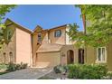 Inviting tan home with a beige two-car garage, an arched entry, and landscaped front yard at 11839 E Maplewood Ave, Greenwood Village, CO 80111