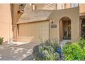 Inviting tan home with a beige two-car garage, arched entry, and a tidy landscaped front yard at 11839 E Maplewood Ave, Greenwood Village, CO 80111