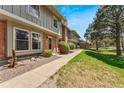 Attractive townhouse featuring a concrete sidewalk, well-maintained lawn, and lush green shrubs at 10208 E Jewell Ave # 18, Aurora, CO 80247