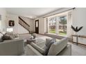 Bright living room with neutral tones, plush carpeting, and a large window at 10208 E Jewell Ave # 18, Aurora, CO 80247