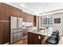 Gorgeous kitchen features a large island, stainless steel appliances, and modern lighting at 4200 W 17Th Ave # 211, Denver, CO 80204
