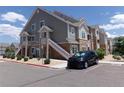 Exterior view of the apartment building, showcasing the architecture and reserved parking with lush landscape at 1851 S Dunkirk St # 201, Aurora, CO 80017