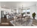 Eat-in kitchen features an island with bar seating, stainless appliances, and an adjacent dining area for entertaining at 9359 Russell Cir, Arvada, CO 80007