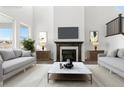 Inviting living room boasts a cozy fireplace, flanked by decorative lamps, and stylish sofas perfect for relaxation at 9359 Russell Cir, Arvada, CO 80007