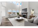 Bright living room features a fireplace, large windows, and high ceilings, creating an inviting and spacious atmosphere at 9359 Russell Cir, Arvada, CO 80007