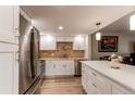 Bright kitchen with stainless appliances, white cabinets, island with white countertop, and tile backsplash at 13961 E Marina Dr # 414, Aurora, CO 80014