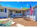 Inviting front porch with seating area, American flag, and well-manicured landscaping at 3313 S Dexter St, Denver, CO 80222