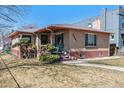 Charming brick home featuring a cozy front porch and well-maintained landscaping at 2301 Vine St, Denver, CO 80205