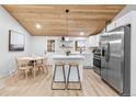 Open concept kitchen with white cabinets, stainless steel appliances, and breakfast bar at 2610 W 90Th Pl, Denver, CO 80260