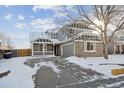 Two-story house with gray siding, stone accents, and a covered porch at 5928 E Conservation Dr, Frederick, CO 80504